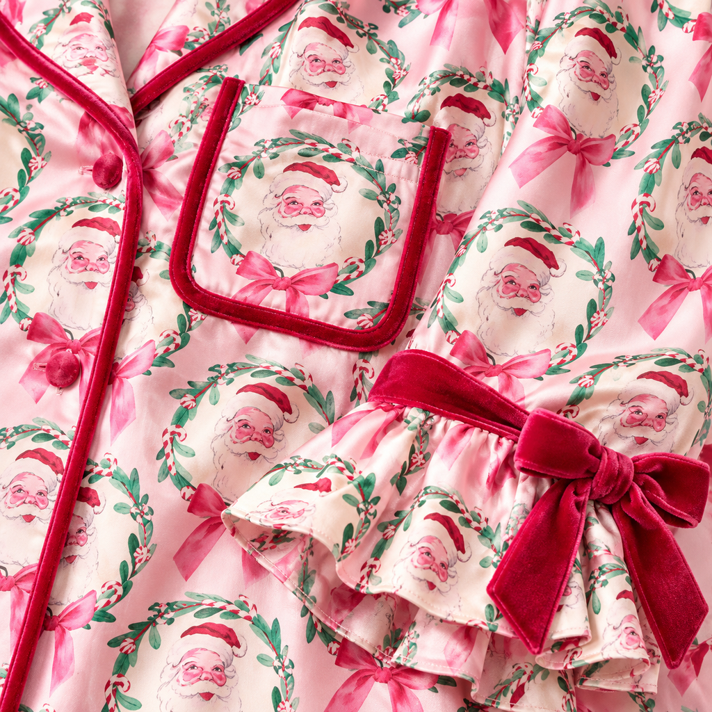 Close-up of vintage Santa wreath print satin with raspberry velvet piping and ruffled bow cuff
