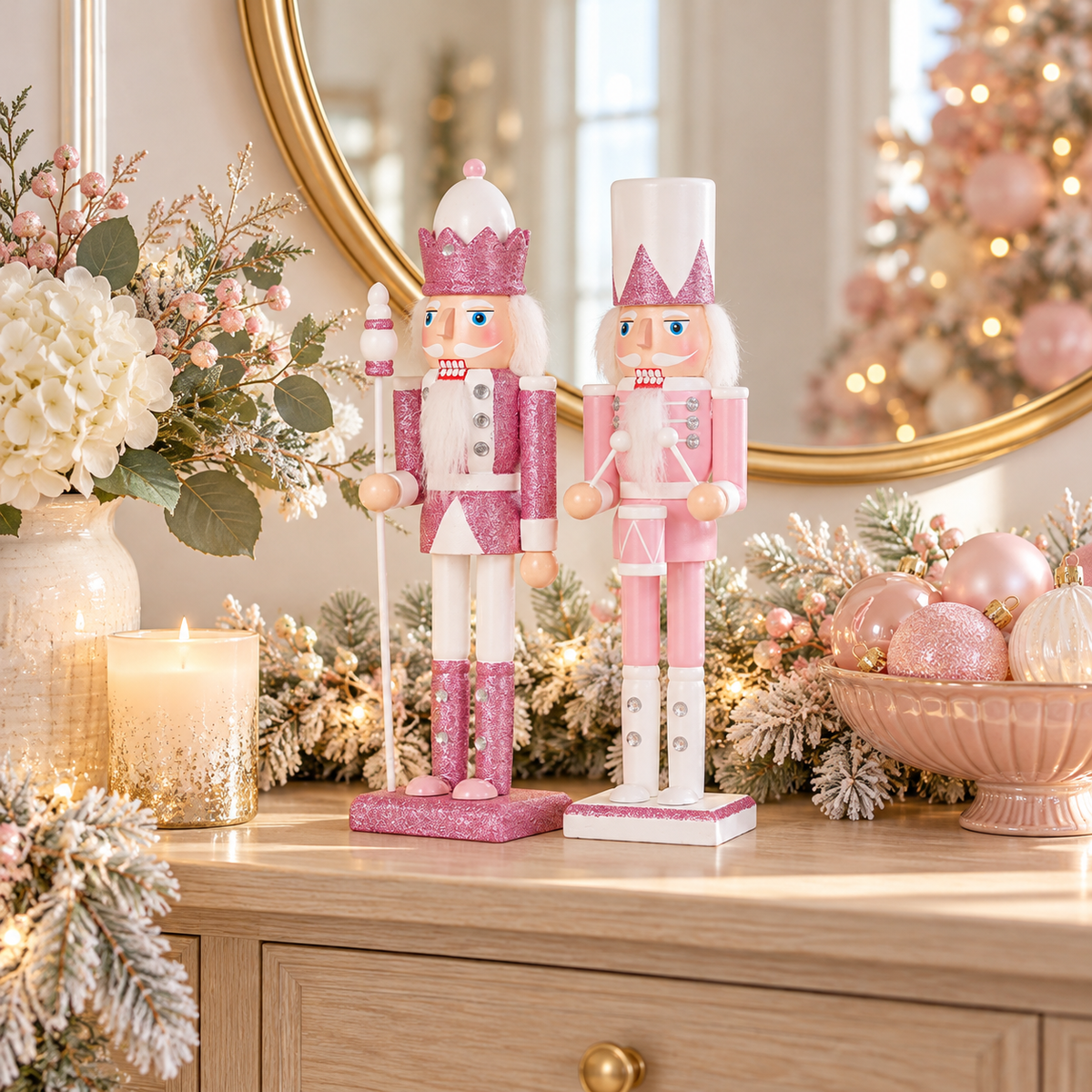 Pink and white Christmas nutcrackers on a wood entryway console with a round gold mirror, white flowers and pastel ornaments