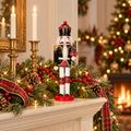 Scottish Highland bagpiper nutcracker on a cream fireplace mantel with evergreen garland, red tartan ribbon, pine cones, brass candlesticks and a lit Christmas tree