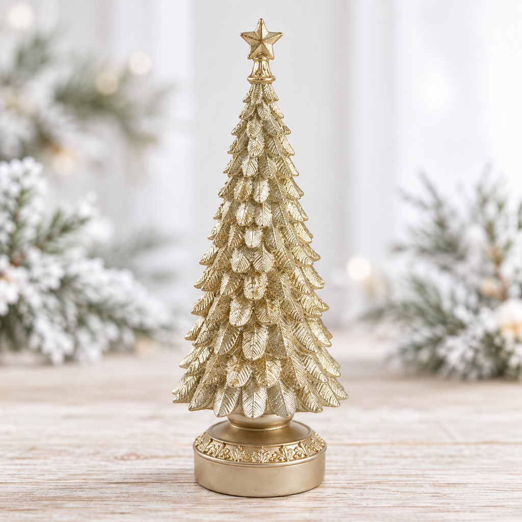 Light gold resin tabletop Christmas tree with star topper beside frosted pine sprigs